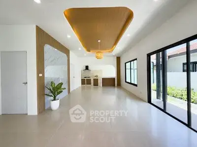 Spacious modern living room with elegant ceiling design and large windows for natural light.