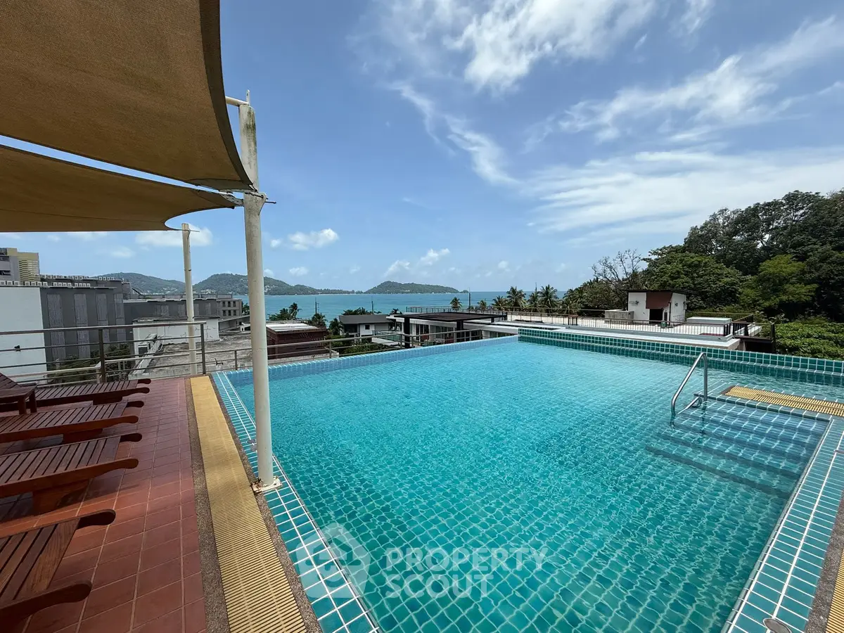 Stunning rooftop pool with ocean view and sun loungers, perfect for relaxation.