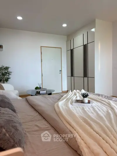 Cozy bedroom with modern decor and soft lighting, featuring a stylish wardrobe and comfortable bedding.