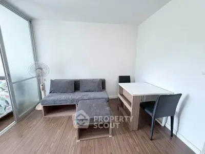 Modern living room with sleek furniture and wooden flooring, featuring a cozy sofa and dining area.