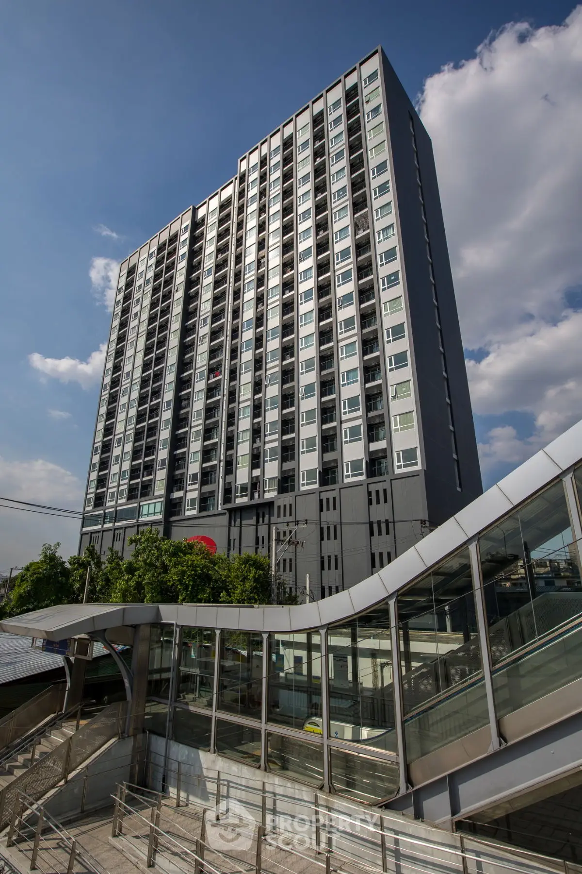 Modern high-rise building with sleek design and clear blue sky backdrop.