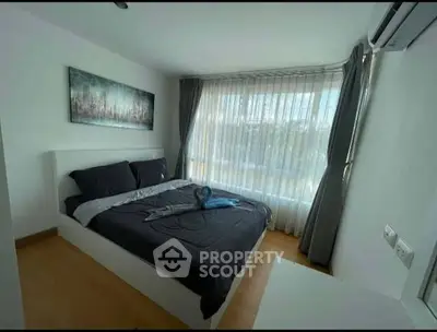 Modern bedroom with large window and stylish decor in a bright apartment