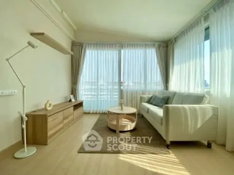 Bright and spacious living room with modern decor and large windows offering city views.