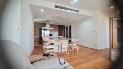Spacious open-plan living room with modern kitchen and dining area, featuring wooden flooring and ample natural light.