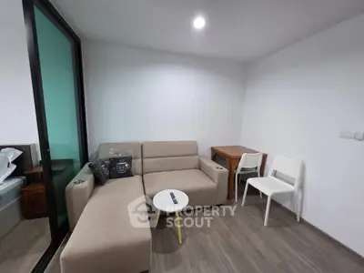 Cozy living room with modern beige sofa and small dining area