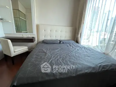 Modern bedroom with city view, featuring a comfortable bed and elegant decor.