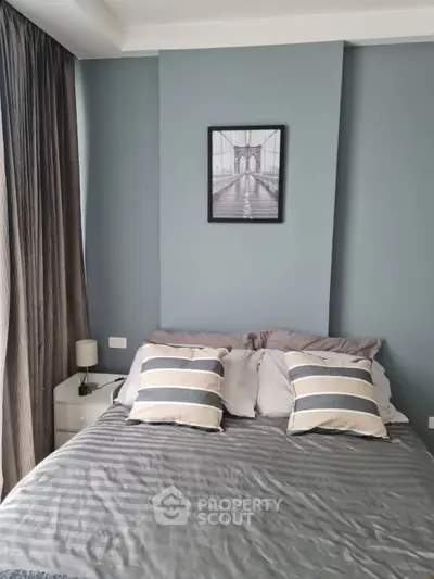 Cozy bedroom with stylish decor and natural light, perfect for relaxation.