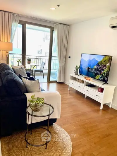 Chic living room with cozy seating and balcony view, perfect for relaxation.