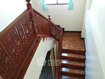 Elegant wooden staircase with intricate railing design in a bright home interior