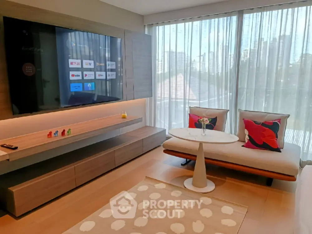 Modern living room with smart TV, stylish furniture, and large windows offering city views.