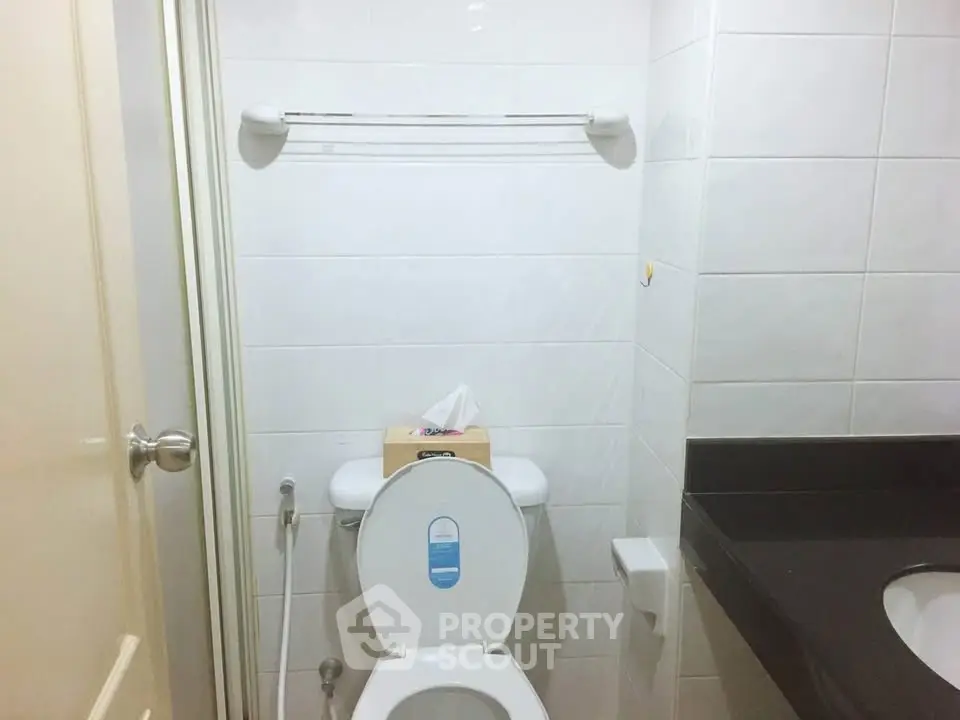 Compact bathroom with modern fixtures and tiled walls