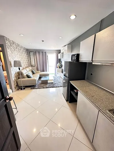 Modern open-layout living room with sleek kitchen and stylish decor in a contemporary apartment.