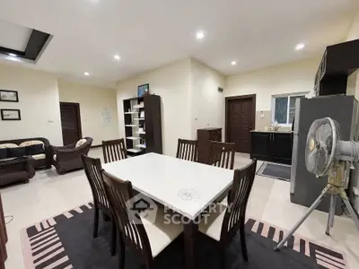 Spacious open-plan living and dining area with modern furnishings and ample lighting.