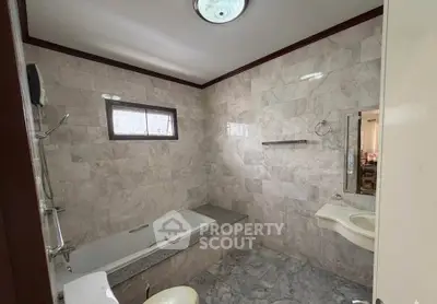 Spacious bathroom with elegant marble tiles and built-in bathtub