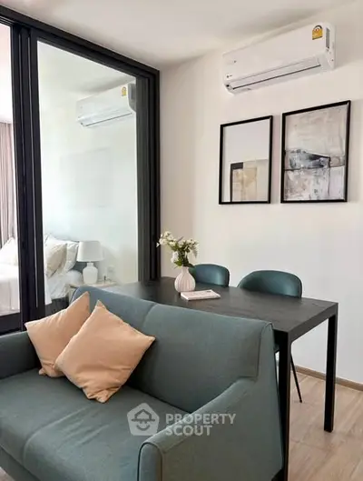 Modern living room with stylish decor and air conditioning, featuring a cozy sofa and elegant dining area.