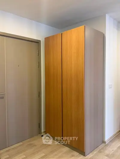 Modern entryway with sleek wooden storage cabinet and neutral tones.