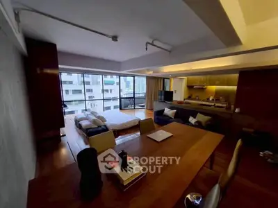 Modern open-layout living room with kitchen and balcony view in urban apartment