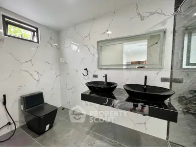 Luxurious modern bathroom with dual black sinks and marble walls