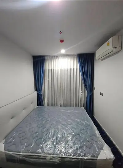 Modern bedroom with blue curtains and air conditioning in a cozy apartment.