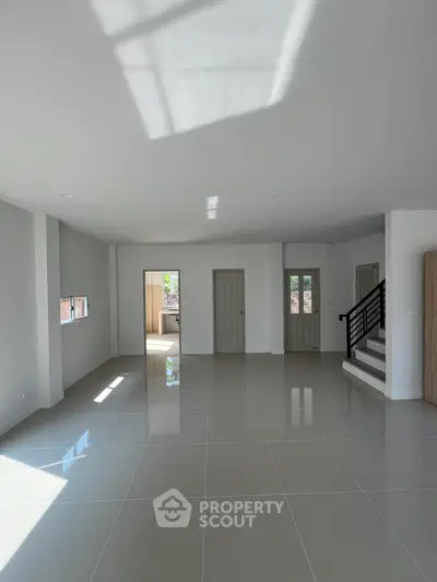 Spacious modern living room with glossy tiled floors and natural light