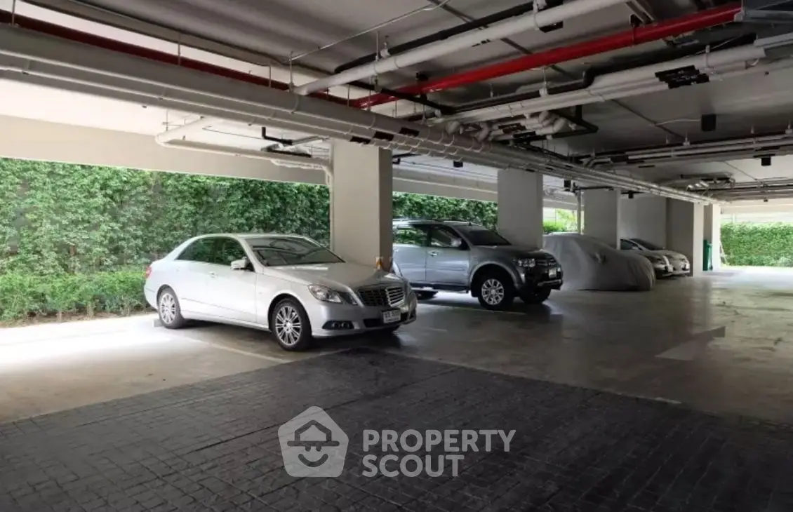 Spacious covered parking area with multiple cars in a modern residential building.