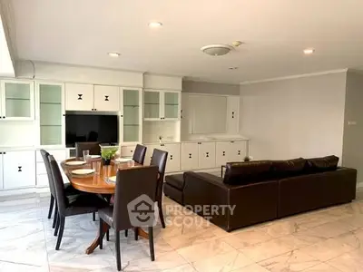 Spacious living room with elegant dining area and modern leather sofa, perfect for family gatherings.