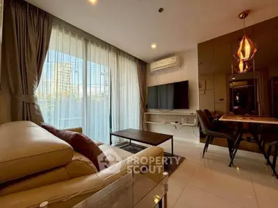 Modern living room with large windows and stylish furniture in a high-rise apartment.