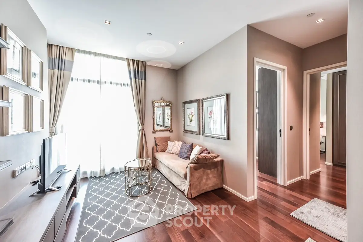 Elegant living room with modern decor and hardwood floors, featuring a cozy sofa and large window.