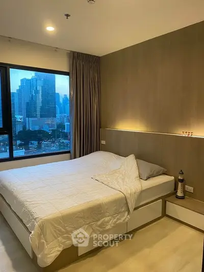 Modern bedroom with city view, featuring elegant lighting and stylish decor, perfect for urban living.