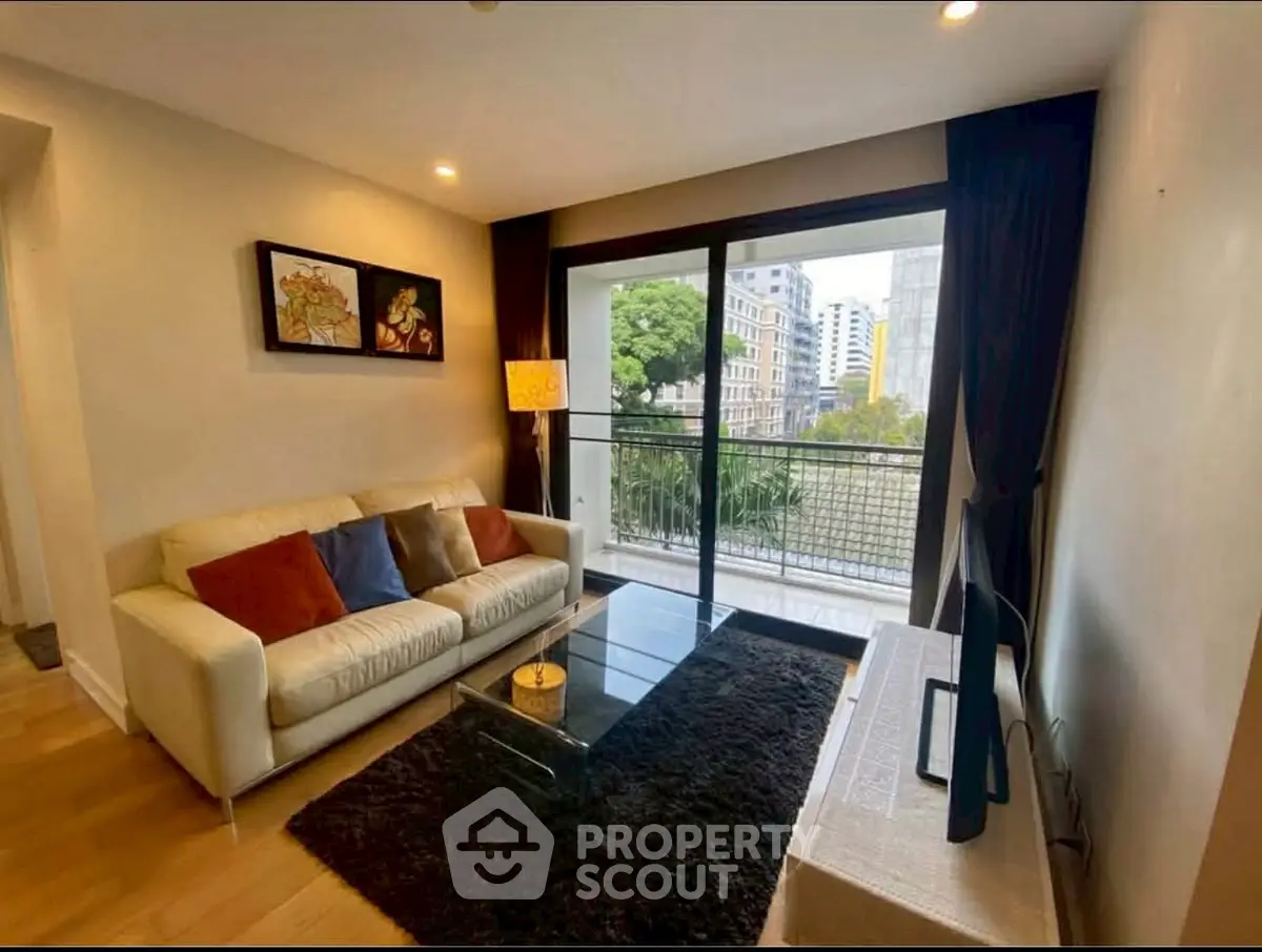 Modern living room with balcony view, stylish decor, and cozy seating area.