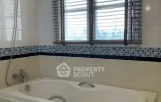 Spacious bathroom with modern bathtub and stylish window blinds.