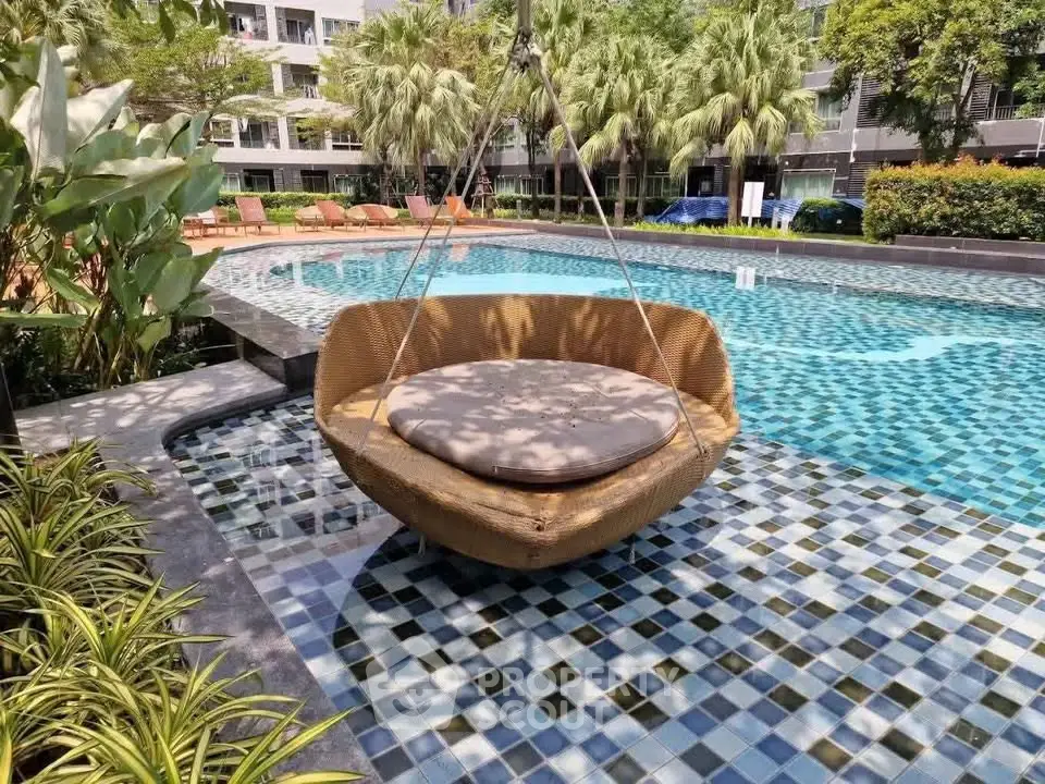 Luxurious poolside area with stylish hanging lounge chair and lush greenery.