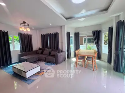 Spacious living room with modern decor and ample natural light, featuring a cozy sofa and elegant dining area.