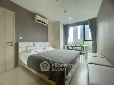 Modern bedroom with large window and city view, featuring sleek furniture and neutral tones.