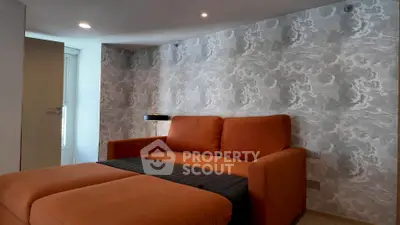Modern living room with stylish orange sofa and textured wall design