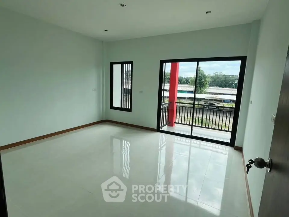 Spacious empty room with large windows and balcony offering scenic views, perfect for customization.