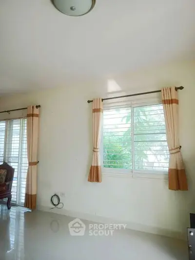 Bright and airy living room with large windows and elegant curtains