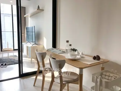 Modern dining area with natural light and sleek furniture in a stylish apartment.