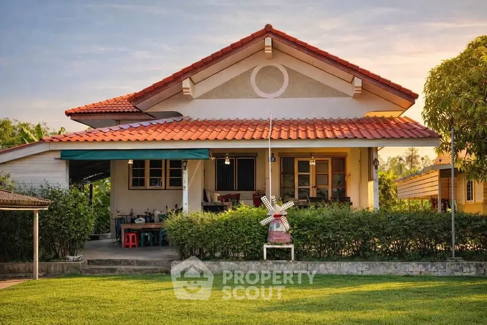 Charming single-story house with red-tiled roof and lush green lawn, perfect for family living.