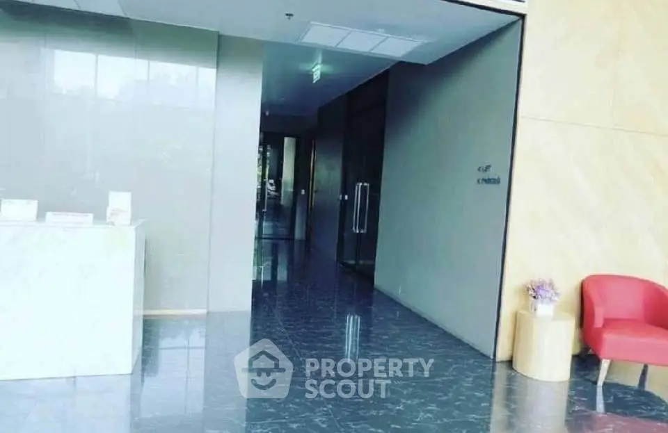 Elegant building entrance with marble flooring and modern decor.