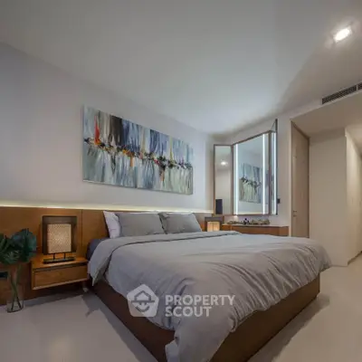 Modern bedroom with stylish decor and cozy ambiance, featuring a large bed and contemporary artwork.