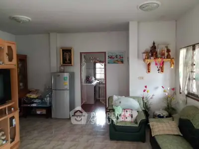 Cozy living room with fridge and traditional decor, perfect for family gatherings.