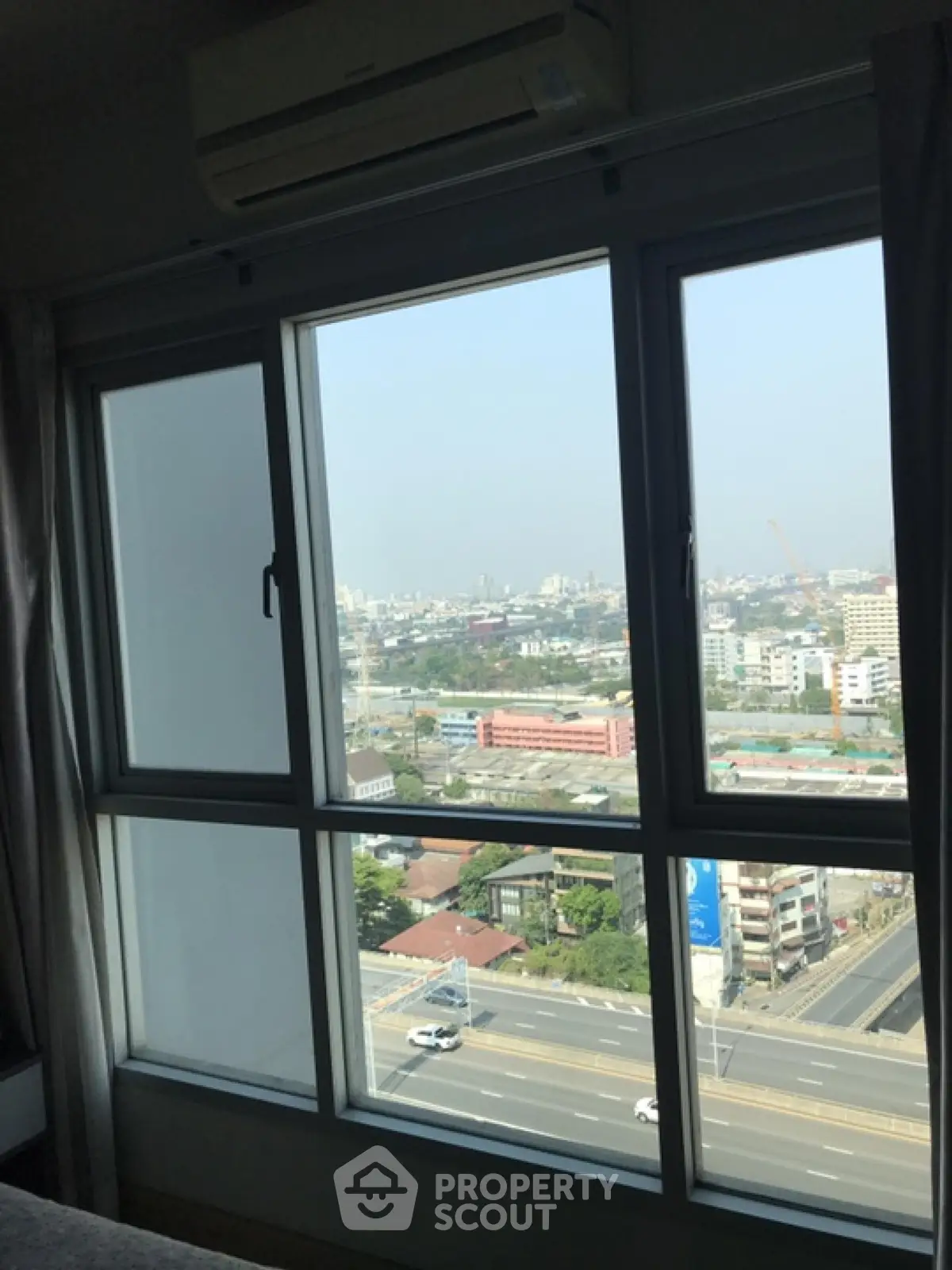 Stunning cityscape view from high-rise apartment window, showcasing urban living at its finest.