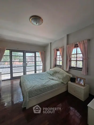 Spacious bedroom with large windows and natural light in a modern home.