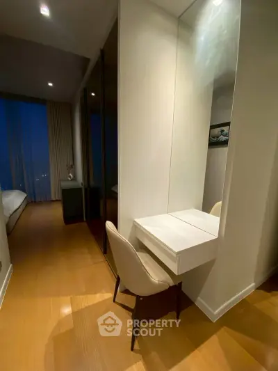 Modern bedroom with sleek vanity and warm wooden flooring