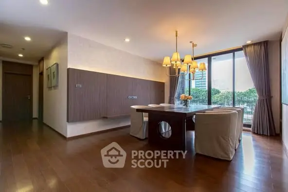 Spacious dining area with elegant lighting and large windows offering a serene view.