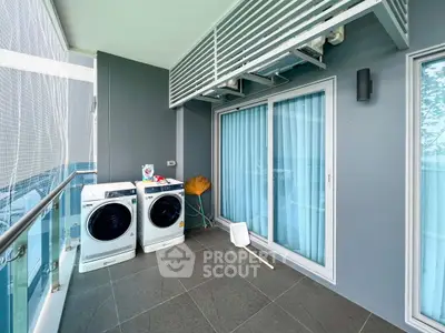 Modern balcony with washing machines and sliding glass doors