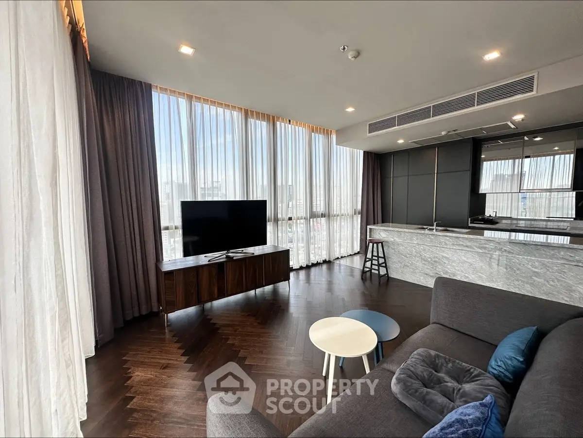 Luxurious modern living room with floor-to-ceiling windows and sleek kitchen island.