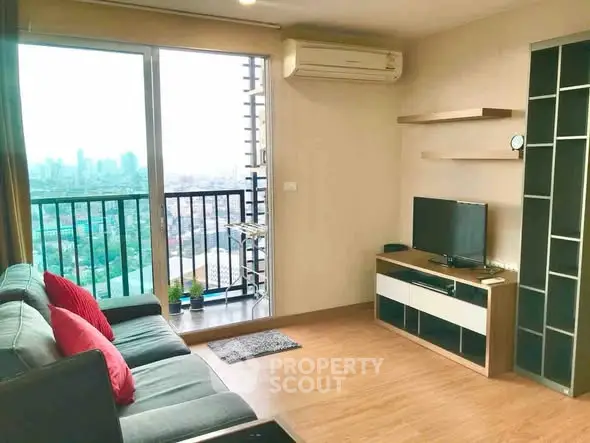 Modern living room with city view and balcony access, featuring stylish furniture and air conditioning.
