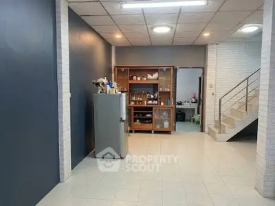 Spacious interior with tiled flooring and modern staircase, ideal for versatile living space.